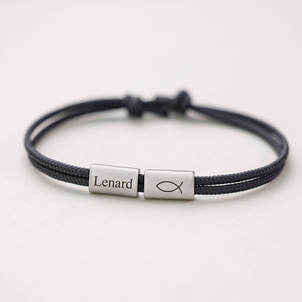 Segeltau Armband mit Gravur in Schwarz, silbernes Plättchen mit Namen und Fisch-Symbol