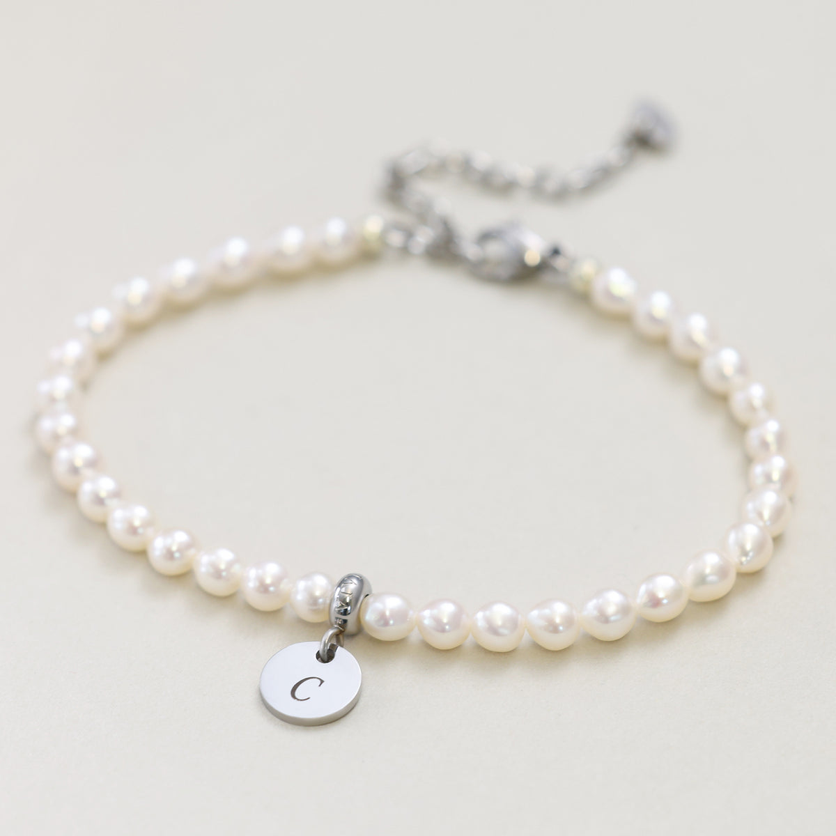 Perlenarmband mit rundem Plättchen in Silber, graviert mit der Initiale C