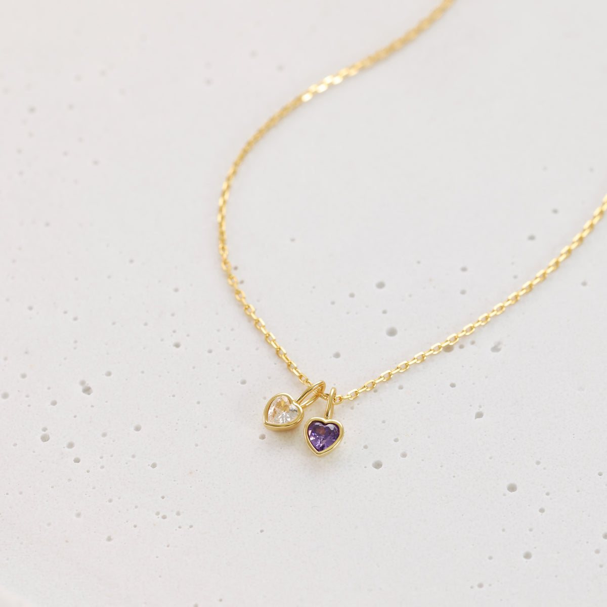 Geburtsstein-Kette in Gold mit zwei herzförmigen Zirkonia-Anhängern in Weiß und Lila