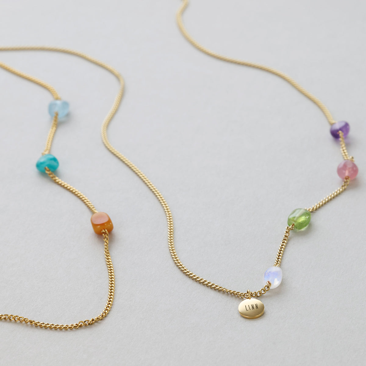 Individuelle Heilenergie-Kette mit personalisiertem Plättchen in Gold mit bunten Edelsteinen und graviertem Namen