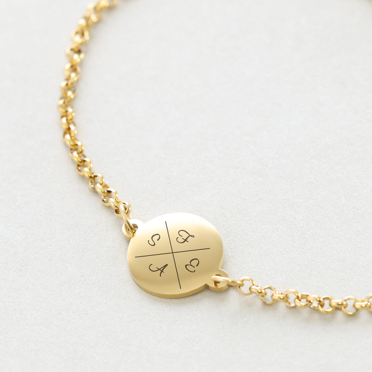 Personalisiertes Armband mit Gravur in Gold – Detailansicht des runden Plättchens mit vier Initialen