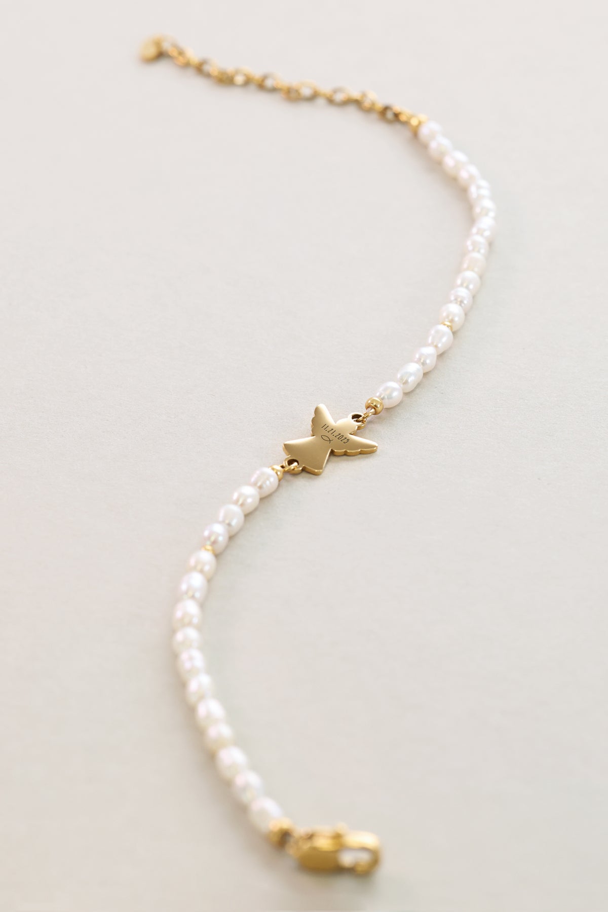 Detailansicht der Süßwasserperlen und des goldenen Schutzengel-Anhängers am Armband