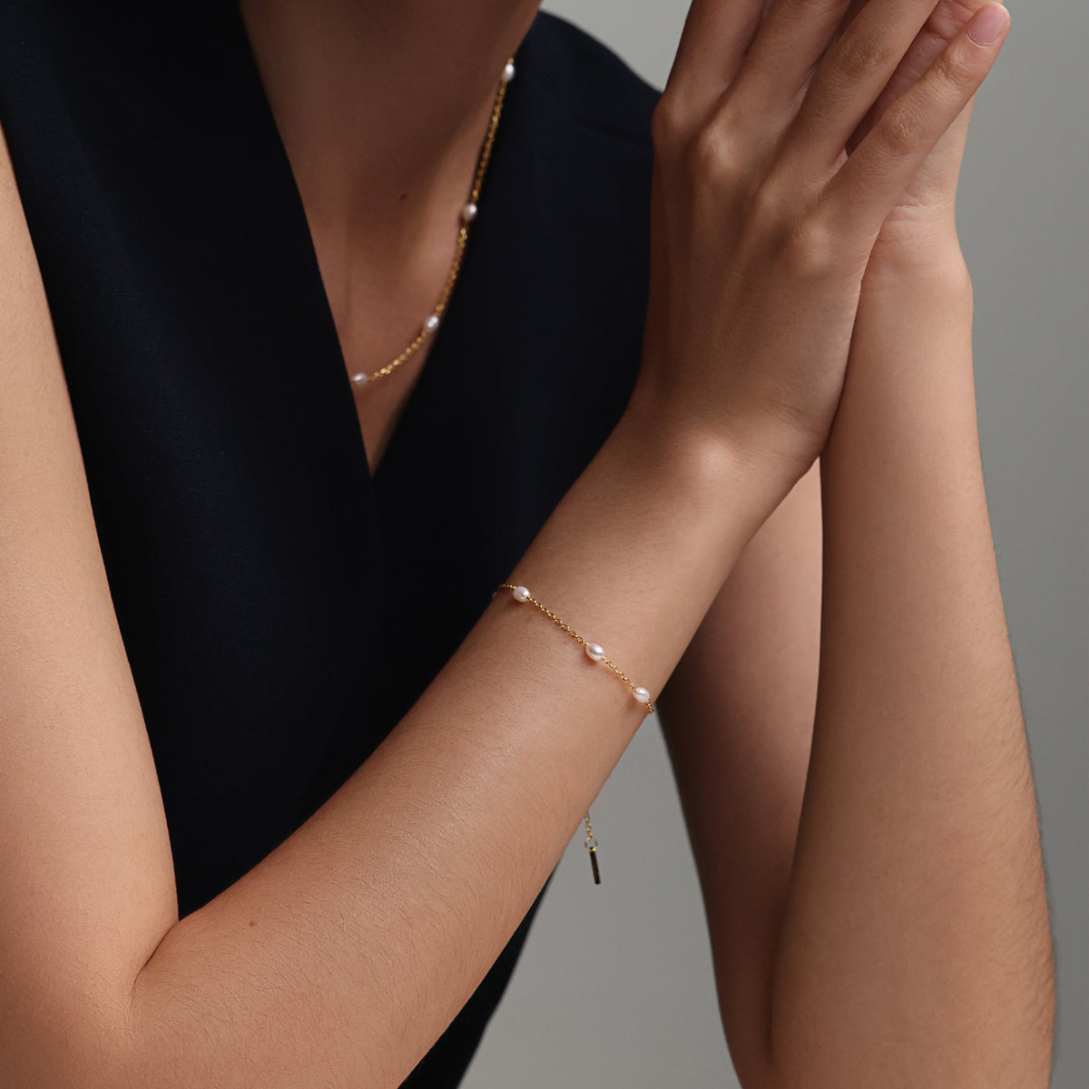 Feines Armband mit kleinen Süßwasserperlen - 925er Sterling Silber, Frau trägt Armband neben Halskette