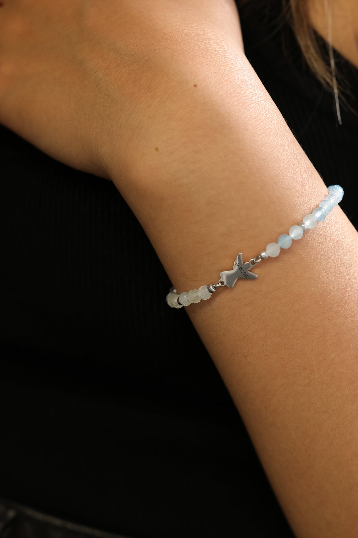 Frau trägt Aquamarin Armband mit Engelanhänger in Silber – Nahaufnahme am Handgelenk