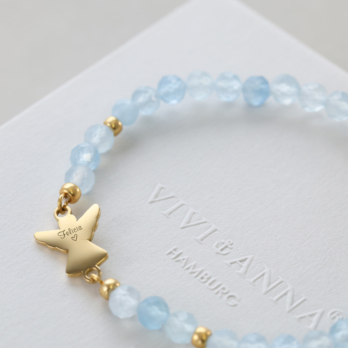 Nahaufnahme des Engelanhängers mit Gravur „Felicia“ am Aquamarin Armband