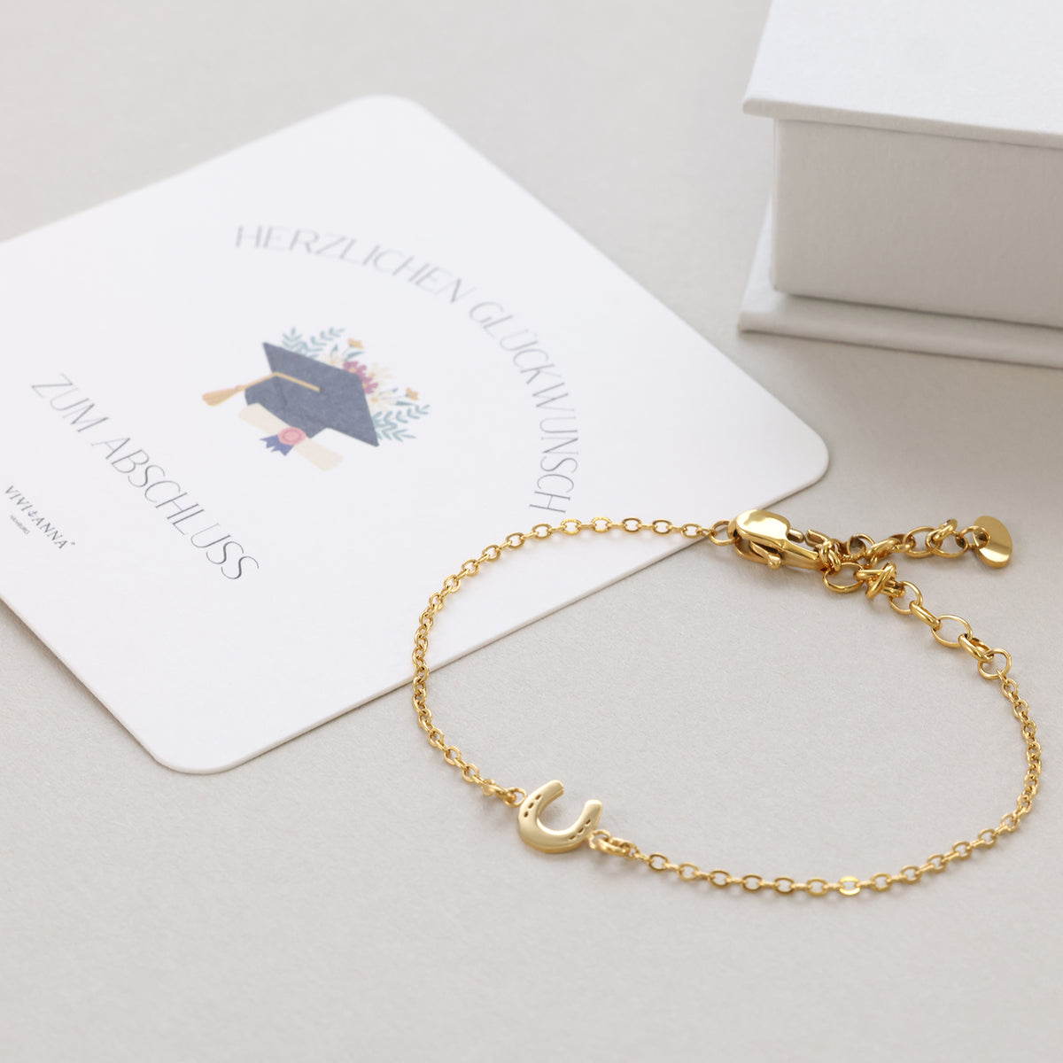 Hufeisen Armband in Gold auf Abschluss-Grußkarte drapiert