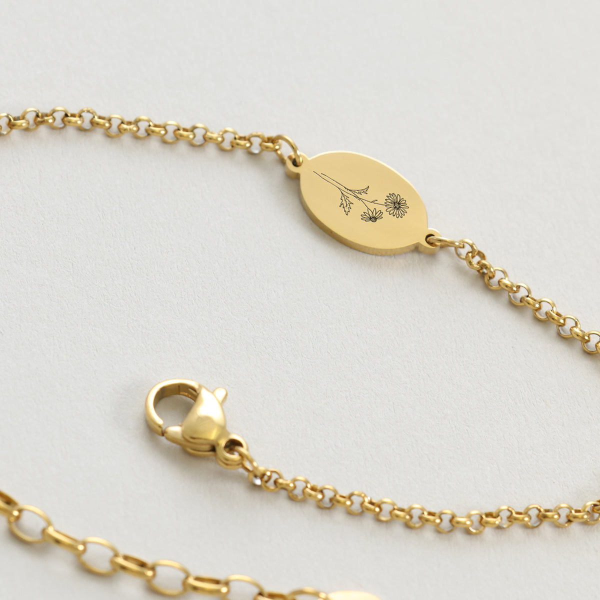Nahaufnahme des Geburtsblumen-Armbands in Gold mit graviertem Blumenmotiv und Verschluss