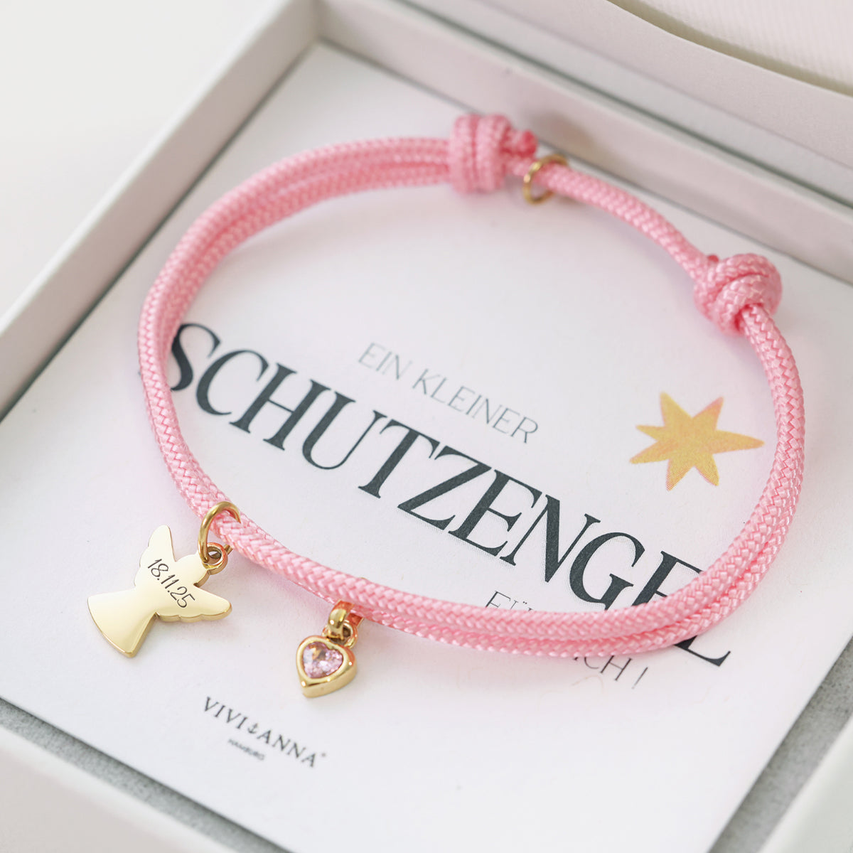 Rosa Segeltau Armband mit graviertem Datum am Schutzengel-Anhänger und rosa Herz-Geburtsstein in Geschenkbox