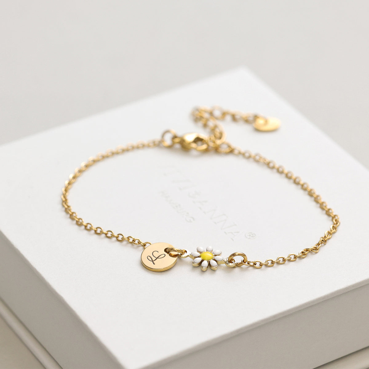 Gänseblümchen Armkette mit Gravurplättchen – Armband auf weißer Geschenkbox drapiert