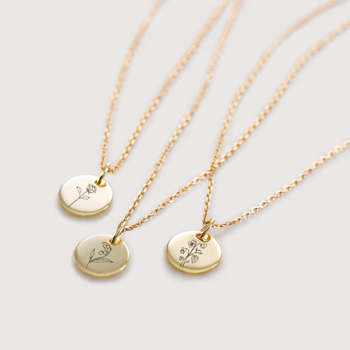 Personalisierte Geburtsblumen Kette in Gold – drei Anhänger mit unterschiedlichen Blumenmotiven graviert