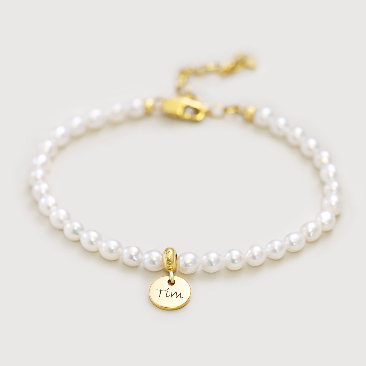 Perlenarmband mit rundem Plättchen in Gold, graviert mit dem Namen Tim