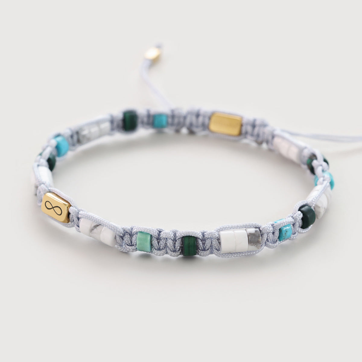 Makramee Armband aus Howlith, Malachit und Türkis mit goldener Gravurplakette, flach liegend