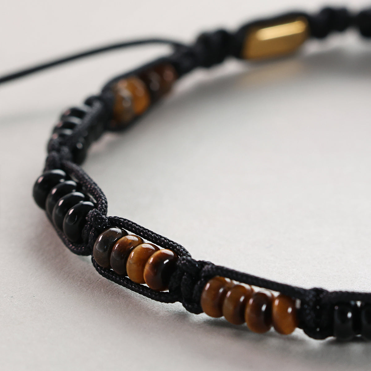 Detailansicht der Tigerauge- und Onyx-Perlen am Makramee Armband