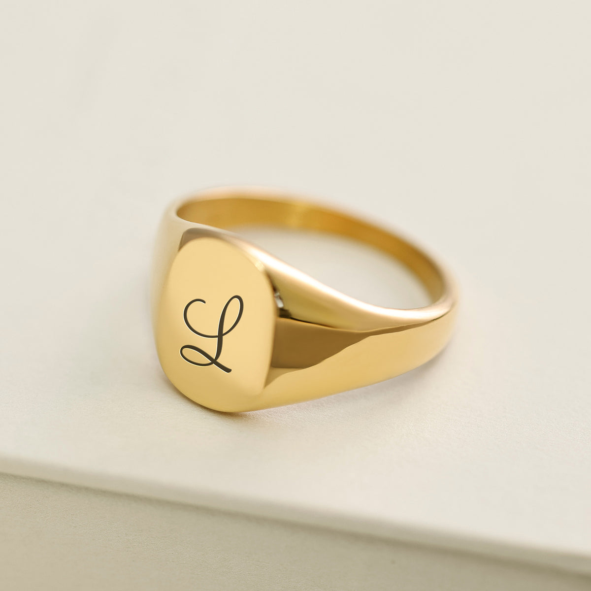 Goldener Siegelring mit verschnörkelter Gravur des Buchstabens L