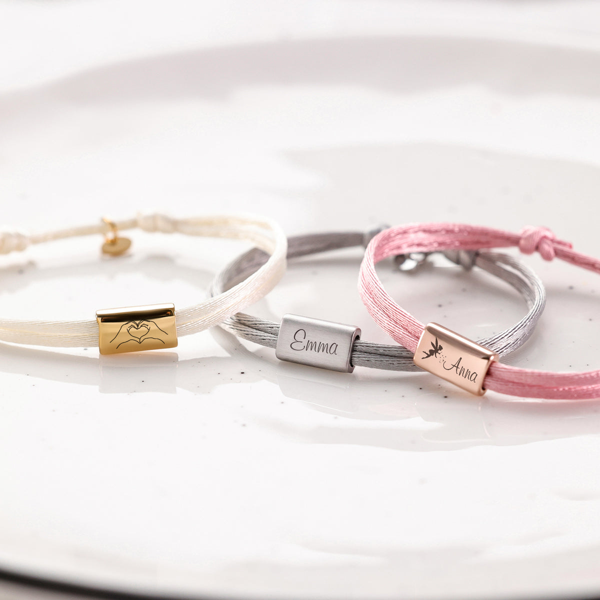 Drei Kinder Satinband Armbänder mit Gravur in Creme, Grau und Rosa – Herz-Symbol, Emma und Anna mit Libellen-Symbol