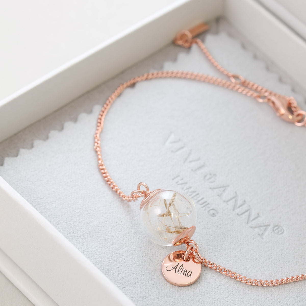 Frau trägt Pusteblumen-Armband mit Wunschgravur am Handgelenk, Hände am Gesicht