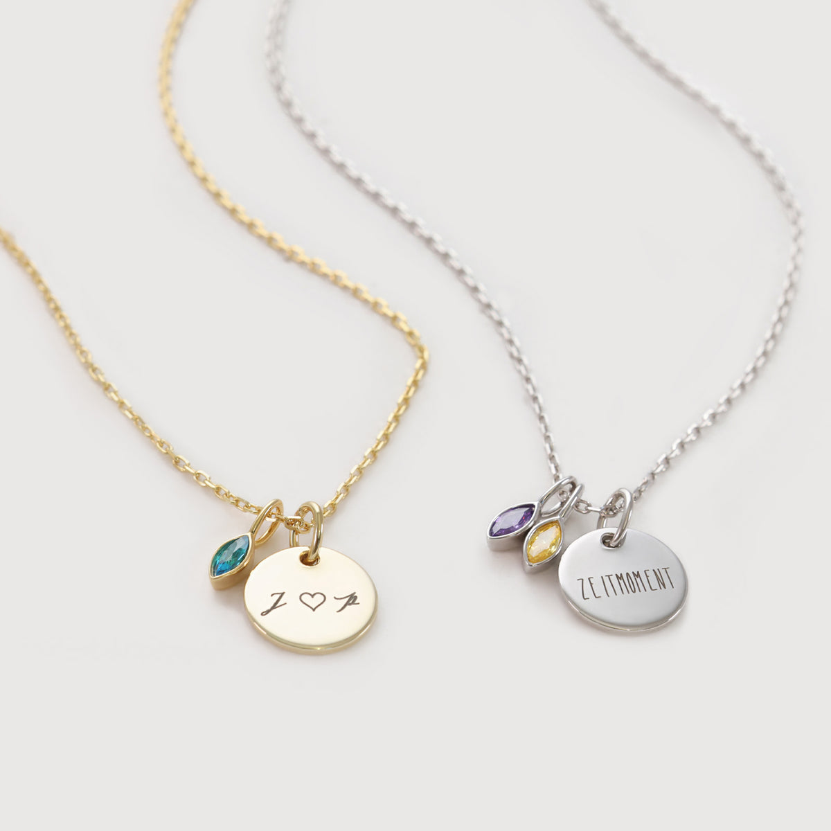Personalisierte Kette mit Navette-Geburtsstein in Gold und Silber im Vergleich, graviert mit 'J♥P' und 'Zeitmoment'