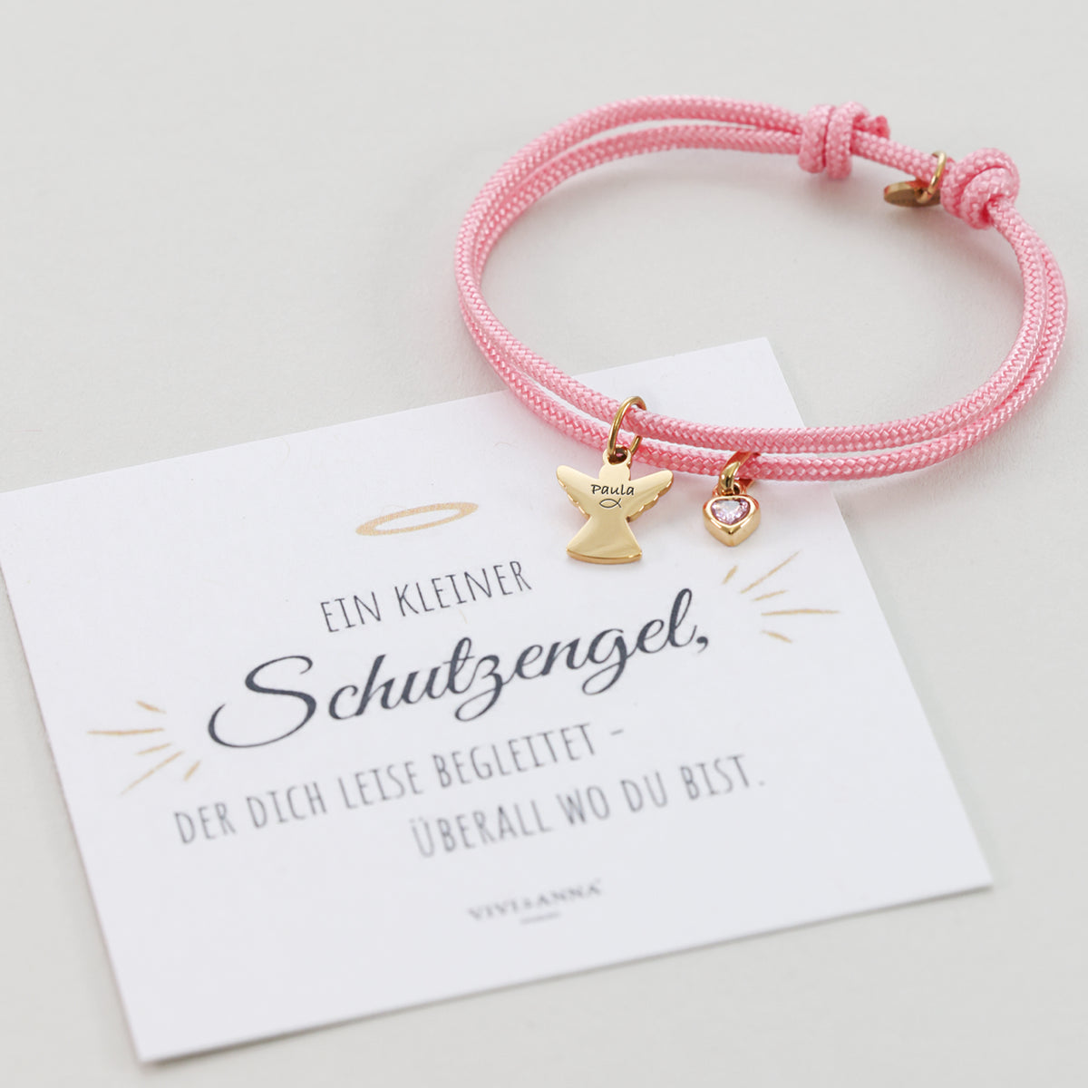 Rosa Segeltau Armband mit goldenem Schutzengel-Anhänger, graviert mit Namen Paula, auf Schutzengel-Grußkarte
