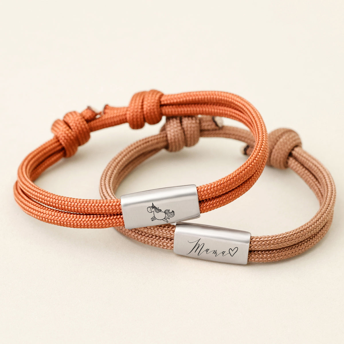 Zwei Segeltau Armbänder mit Wunschgravur in Orange und Braun, graviert mit Einhorn-Symbol und Mama