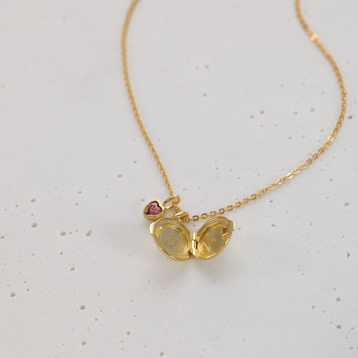Geöffnetes Mini Medaillon in Gold mit rosa Herz-Geburtsstein, Innenansicht der Anhänger