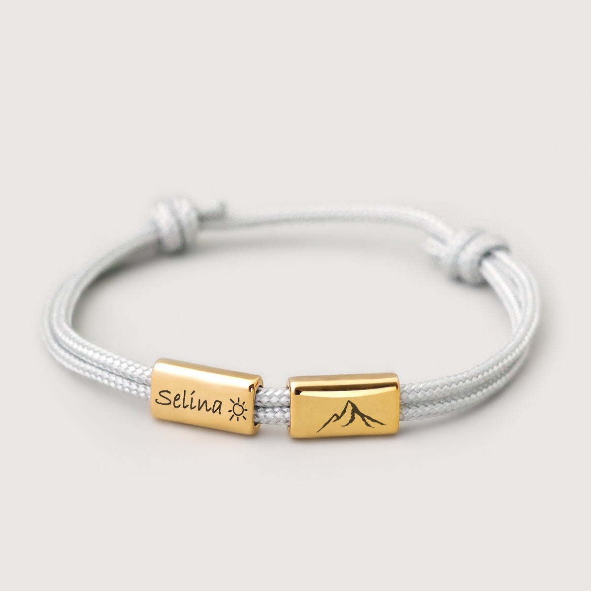 Personalisiertes Segeltau Armband mit 2 Gravurperlen in Gold – graue Kordel mit Namen 'Selina' und Bergmotiv