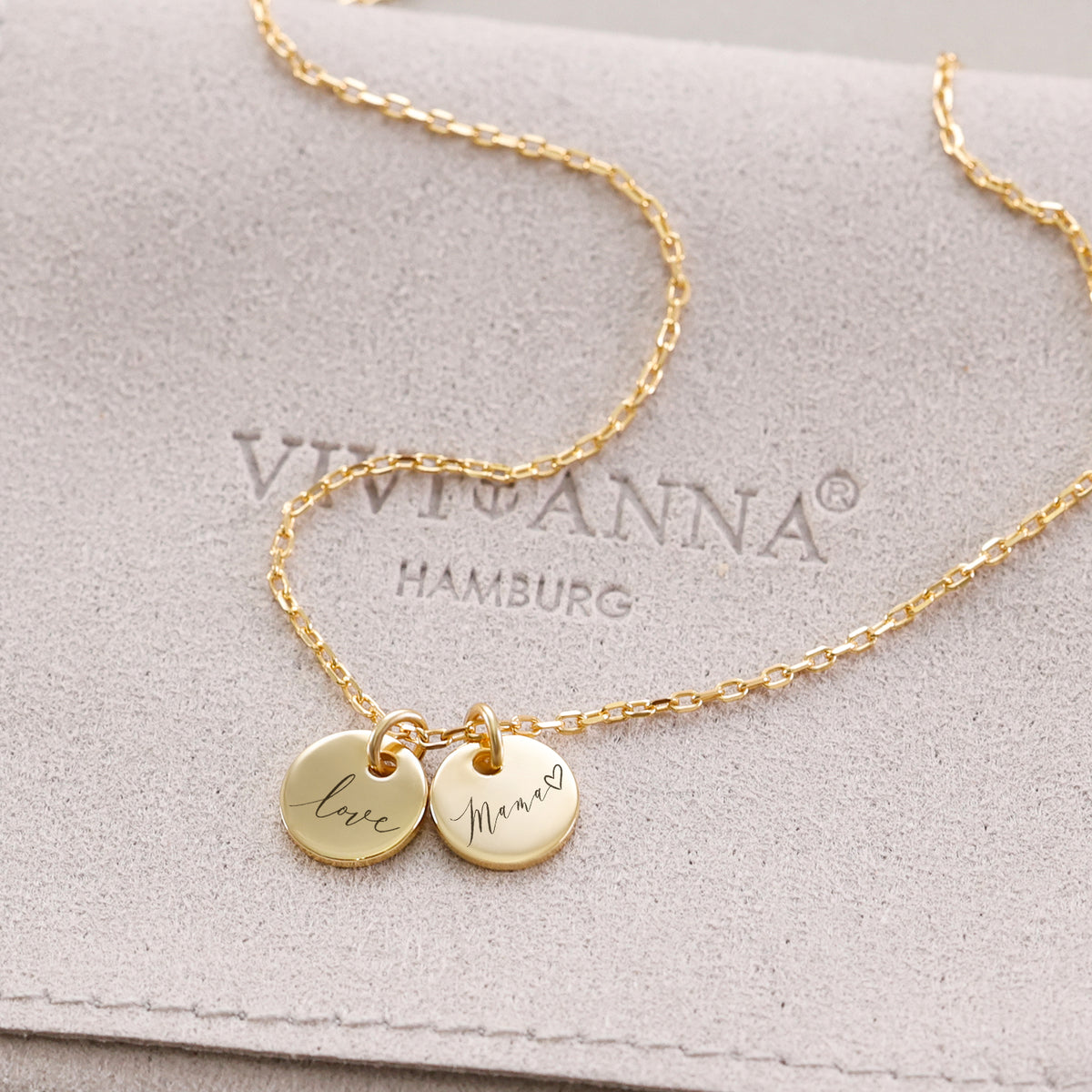 Personalisierte Kette mit rundem Plättchen in Gold – zwei Anhänger mit 'Love' und 'Mama' auf Wildleder-Etui