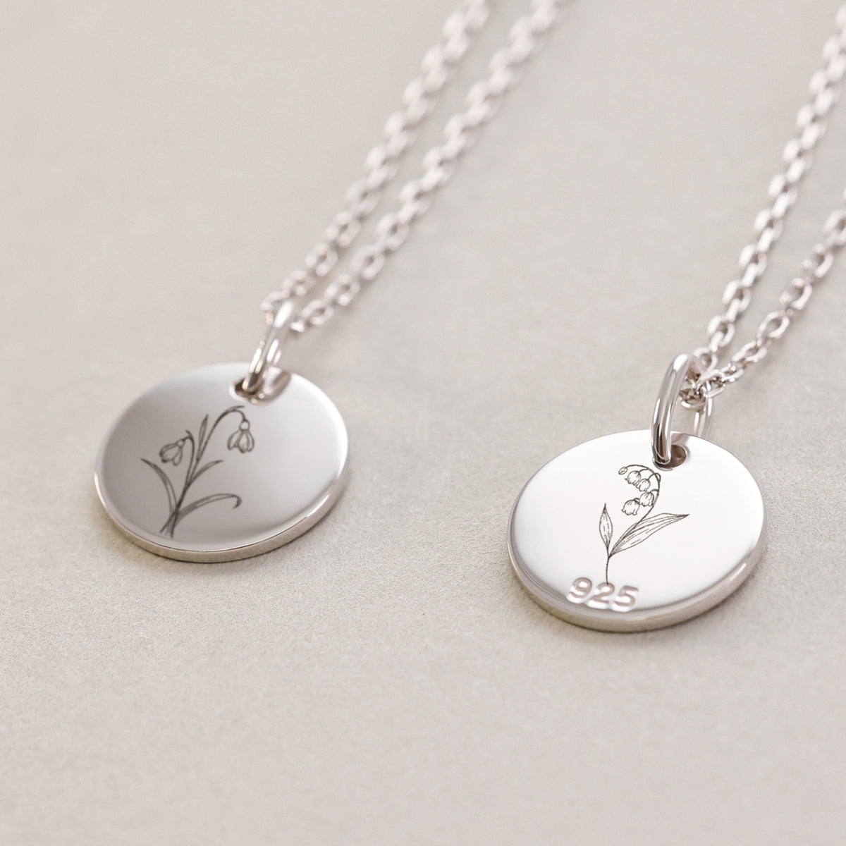 Personalisierte Geburtsblumen Kette in Silber – zwei Anhänger mit Blumenmotiv und '925'-Stempel auf der Rückseite