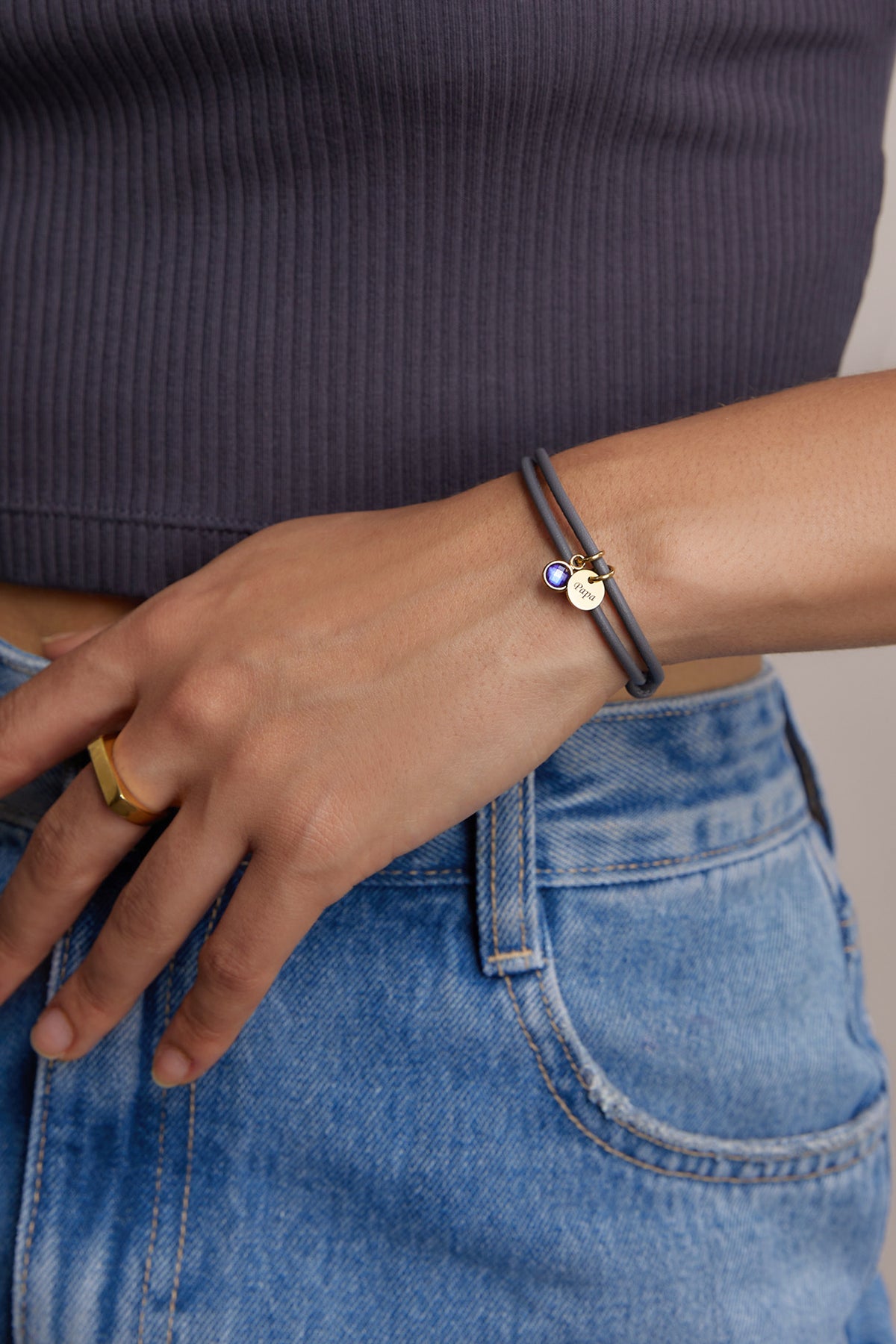 Nahaufnahme des personalisierten Geburtsstein-Armbands aus grauem Nappaleder am Handgelenk