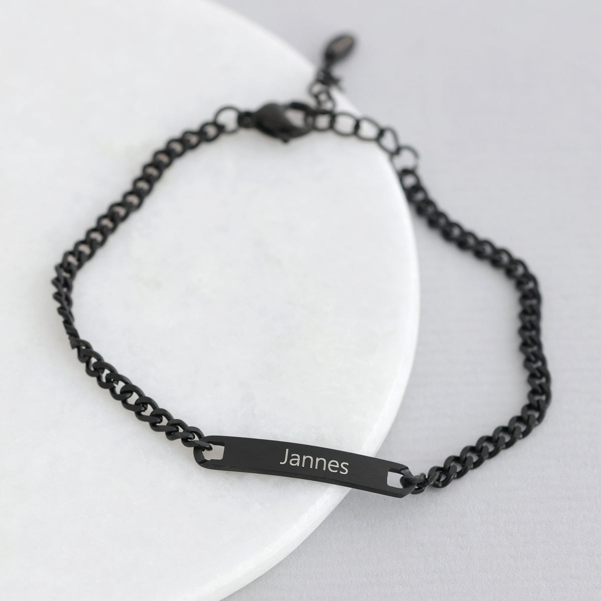 Personalisiertes Armband in Schwarz, Plättchen graviert mit dem Namen 'Jannes'