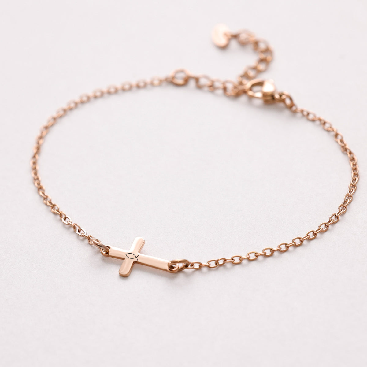 Kreuz-Armband mit Gravur in Roségold, schlichtes Kreuz mit Ichthys-Symbol