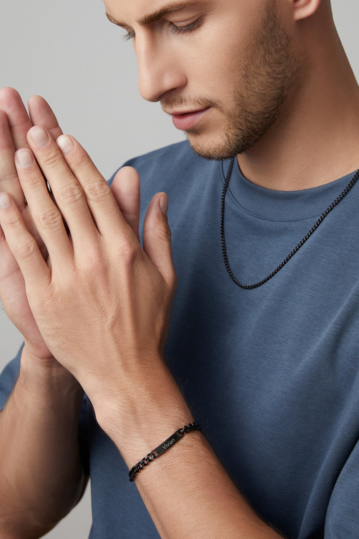 Mann trägt schwarze Halskette und graviertes Panzerarmband mit Namen Vivian