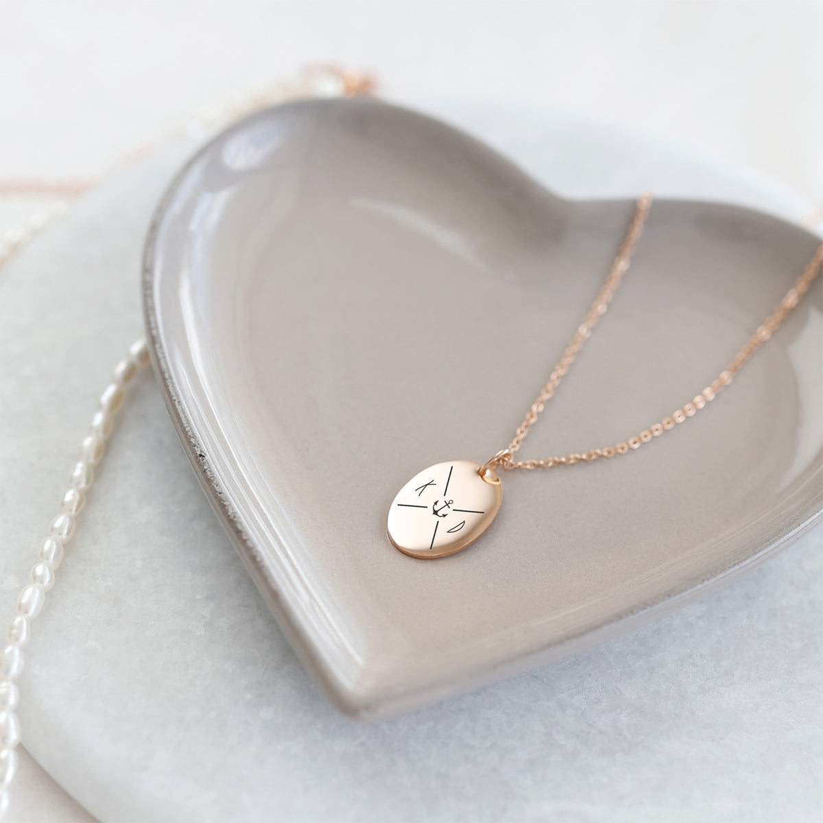 Kette mit graviertem Ovalanhänger in Roségold, Initialen und Ankermotiv, auf herzförmiger Schale
