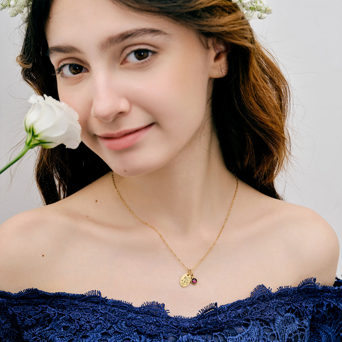 Model trägt Ovales Plättchen-Kette mit Geburtsblume & Geburtsstein in Gold mit weißer Rose