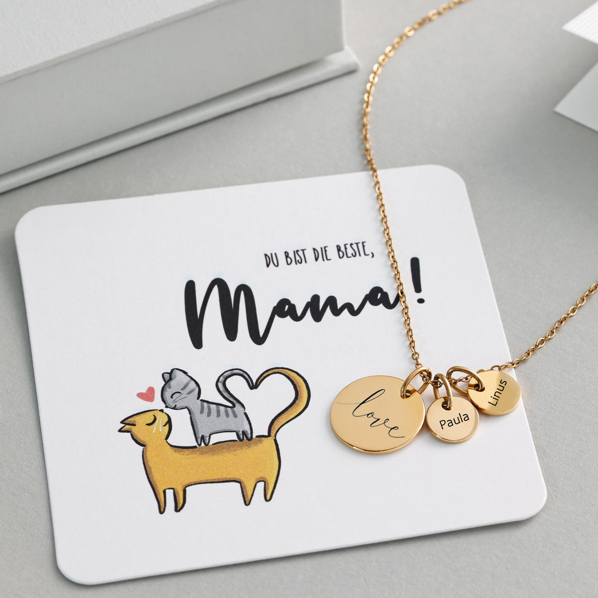 Plättchen-Kette mit Wunschgravur in Gold, Anhänger 'love', Paula und Linus, auf Grußkarte mit Katzen-Motiv