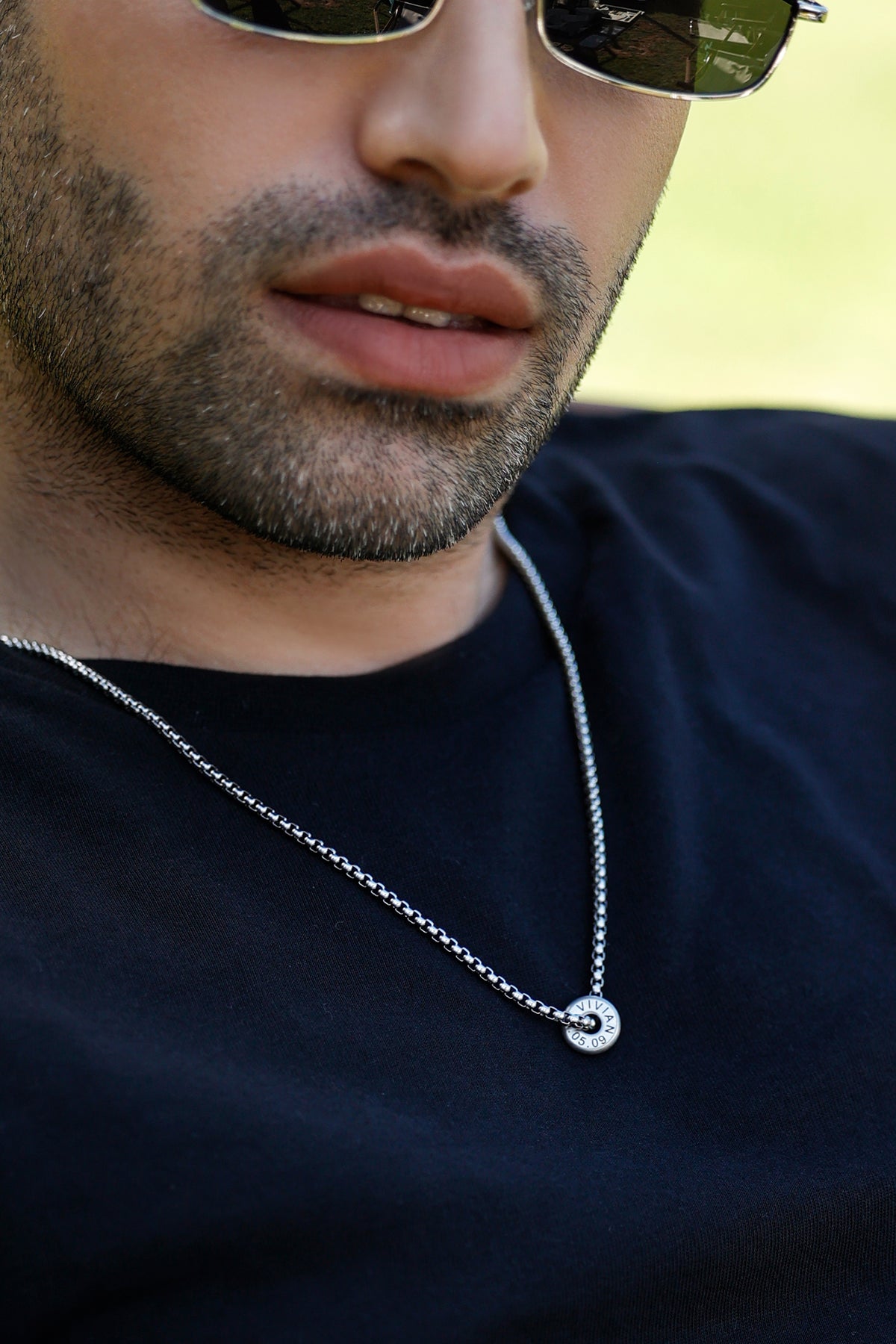 Mann mit Sonnenbrille trägt gravierte Donut-Halskette für Herren in Silber
