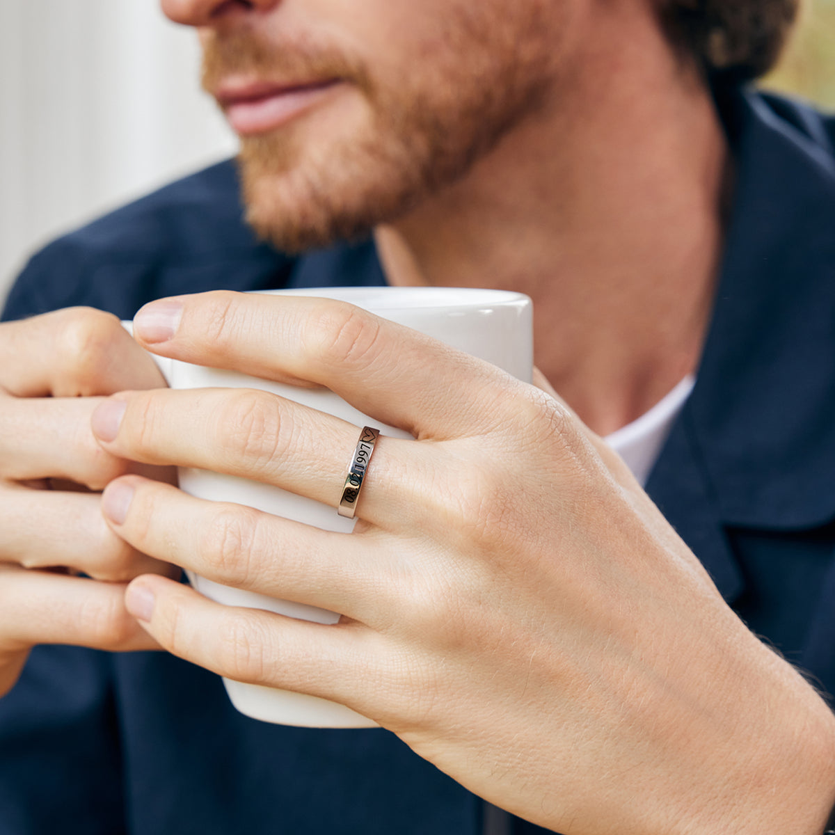 Mann trägt Herren Stapelring mit Gravur in Roségold, Gravur beim Kaffeetrinken sichtbar