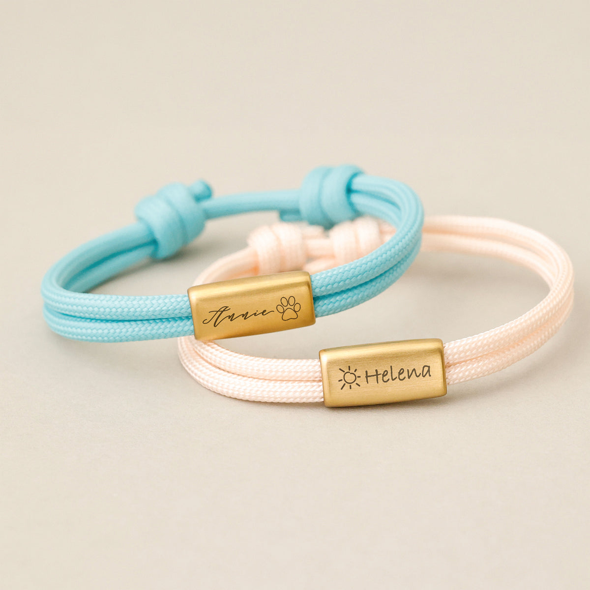 Zwei Segeltau Armbänder mit Gravur in Hellblau und Rosa, Plaketten mit Namen und Symbolen graviert