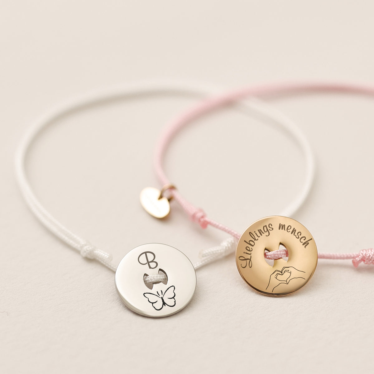 Zwei personalisierte Nylon Armbänder in Weiß und Rosa, graviert mit Schmetterling und Lieblingsmensch
