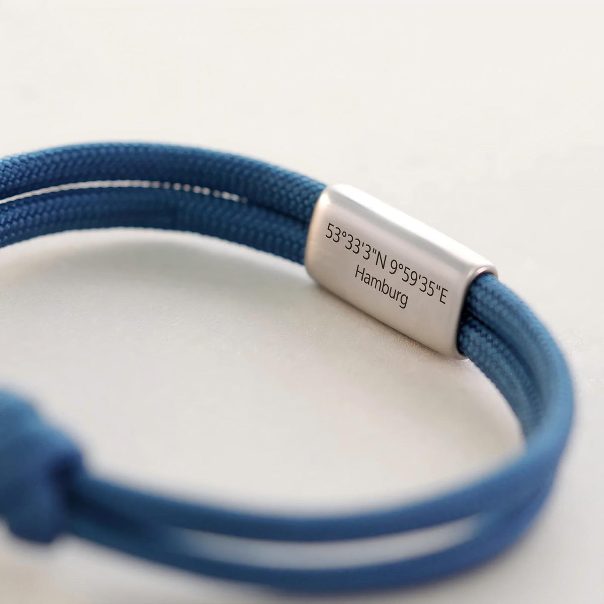 Blaues Segeltau-Armband mit Gravur der Koordinaten von Hamburg auf Edelstahl-Plättchen
