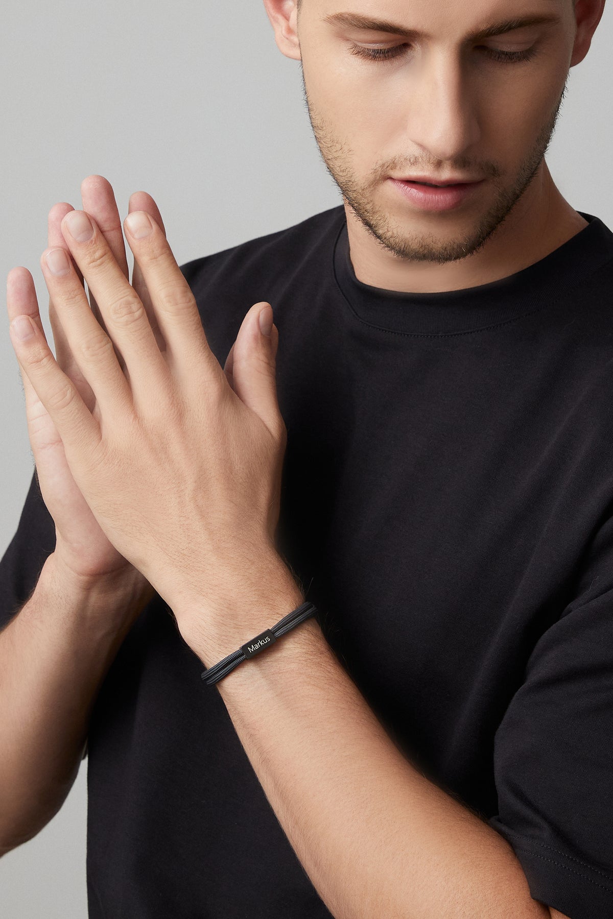 Mann trägt schwarzes Segeltau-Armband mit Gravur Markus am Handgelenk