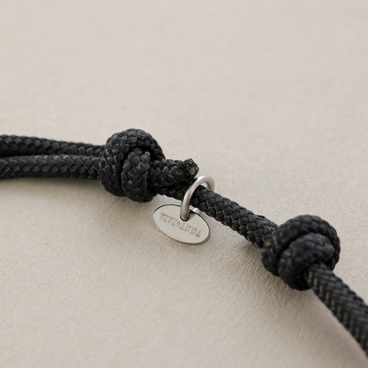 Segeltau Donut Surferarmband in Schwarz mit VIVIANNA-Anhänger am Knoten im Detail