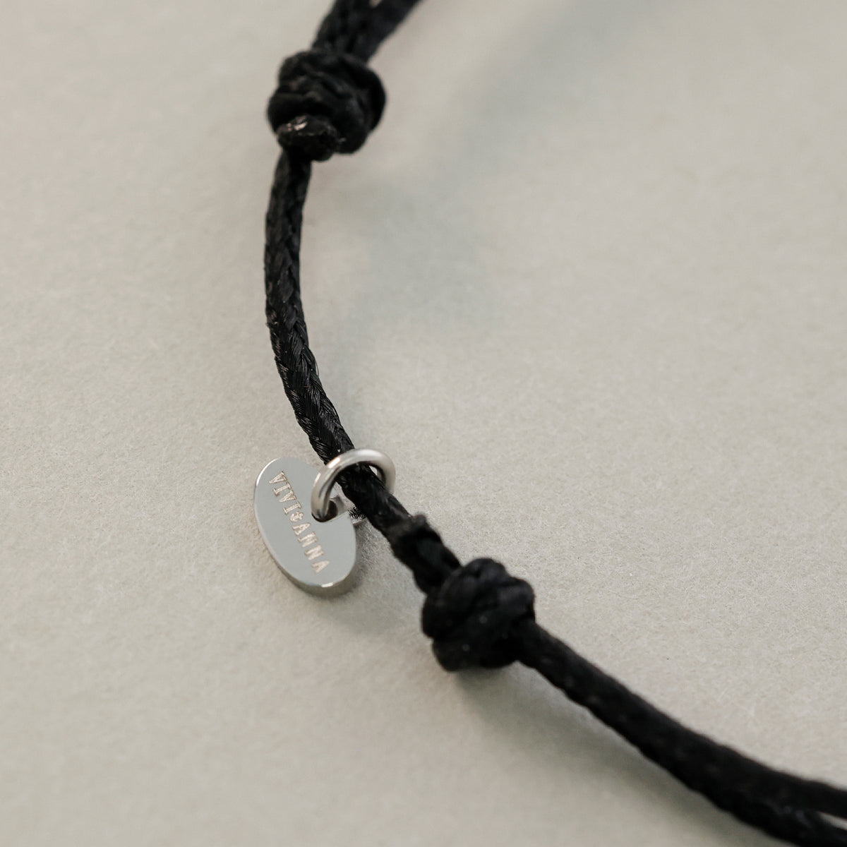 Nylon Armband mit Hammerschlagplättchen in Schwarz mit VIVIANNA-Anhänger am Knoten