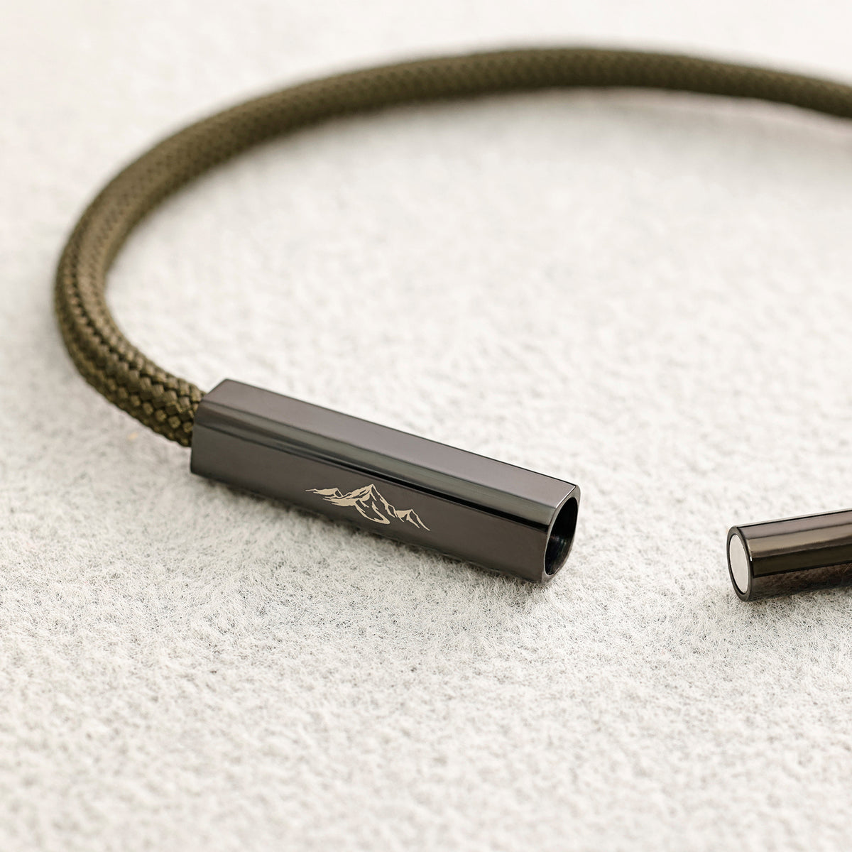 Geöffneter Magnetverschluss des Armbands mit Bergmotiv-Gravur, Nahaufnahme