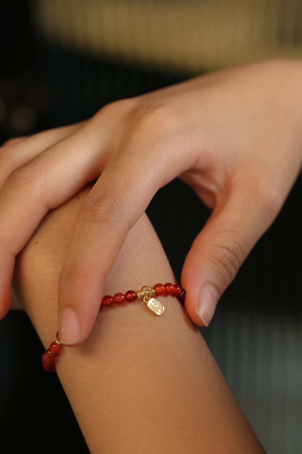 Frau trägt Karneol Armband mit „福“-Anhänger, Nahaufnahme am Handgelenk