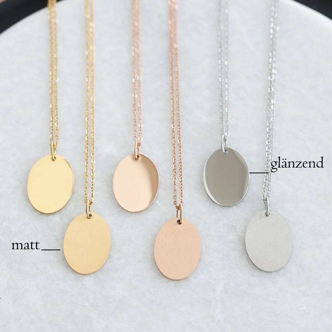 Sechs unbeschriftete Ovalanhänger in Gold, Roségold und Silber, matt und glänzend im Vergleich
